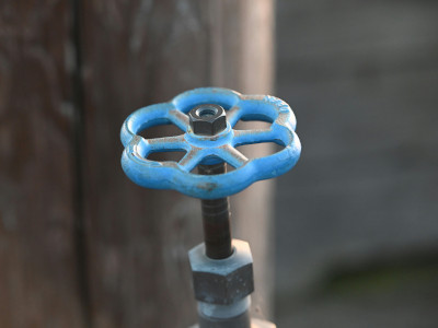 Perilla de válvula azul en sistema de fontanería, representando el relleno con agua potable en lugar de agua gris